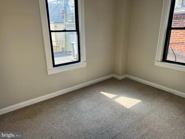 an empty room with windows and closet
