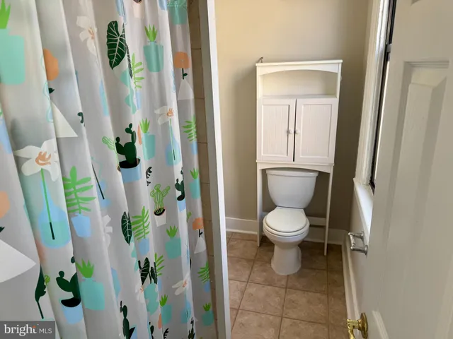 a white toilet sitting next to a bathroom