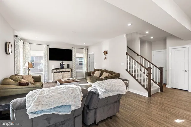 a bedroom with furniture a flat screen tv and a window