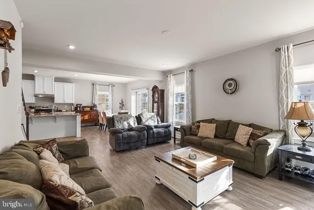a living room with furniture and view of kitchen