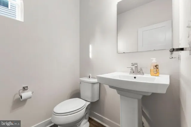 a bathroom with a sink a toilet and mirror