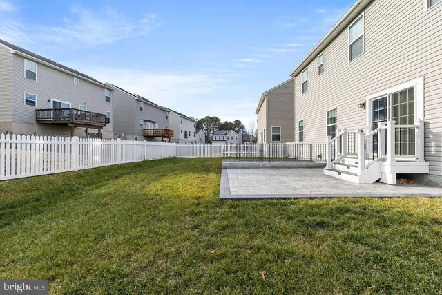 a view of a white house with large windows and a yard