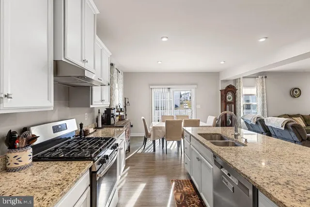 a kitchen with granite countertop a sink stove and cabinets
