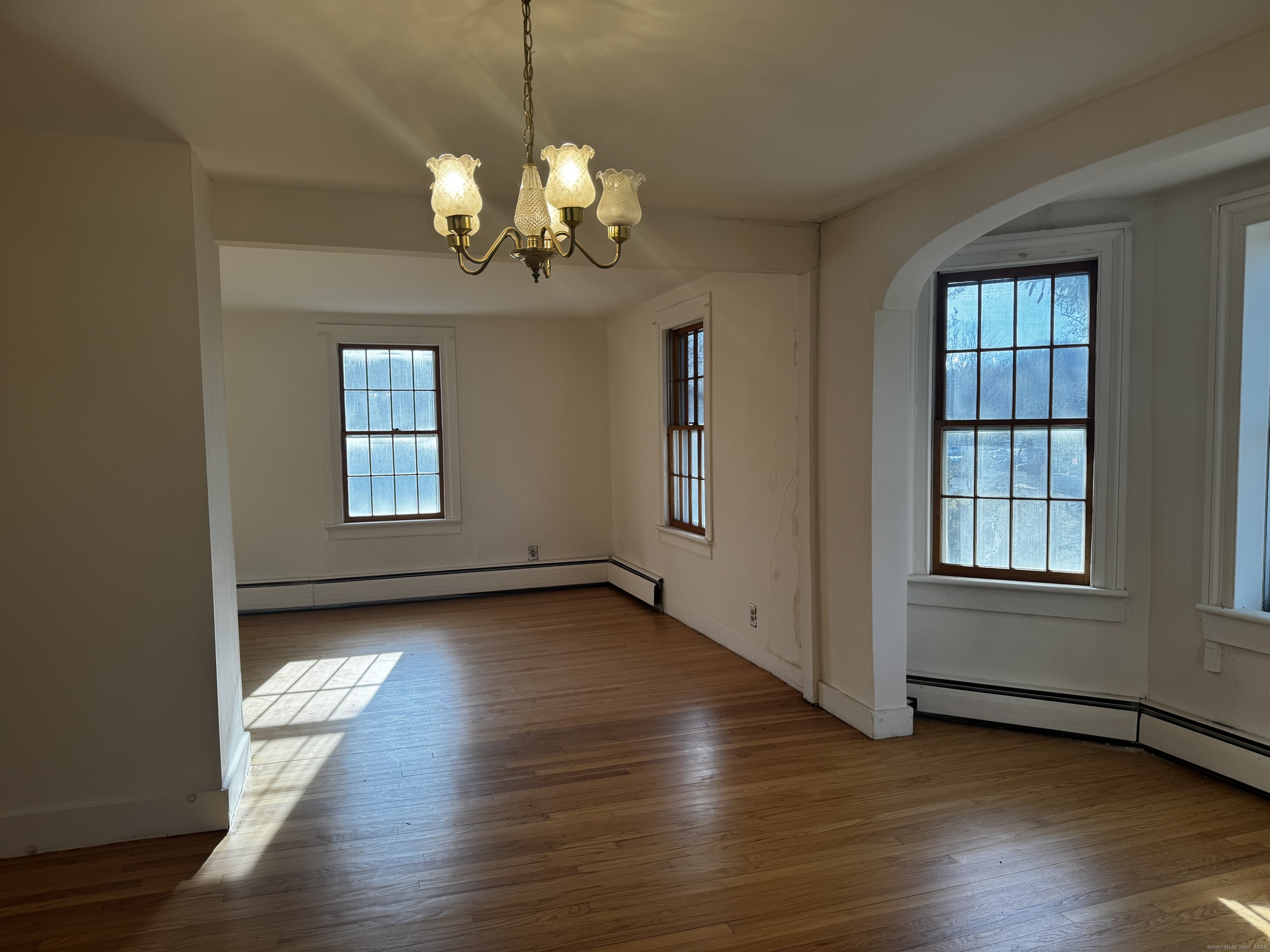 58 Daniels Farm Road Trumbull, CT 06611 - Photo 16 of 40 an empty room with wooden floor chandelier and windows