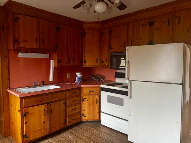 a kitchen with a white stove top oven and refrigerator