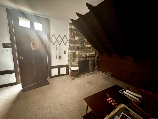 a view of an empty room with wooden floor and stairs