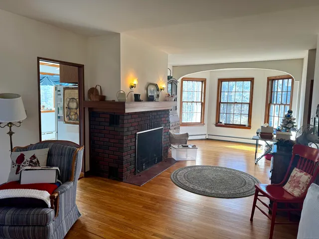 a living room with fireplace furniture and a wooden floor