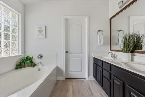 a bathroom with a tub sink and mirror
