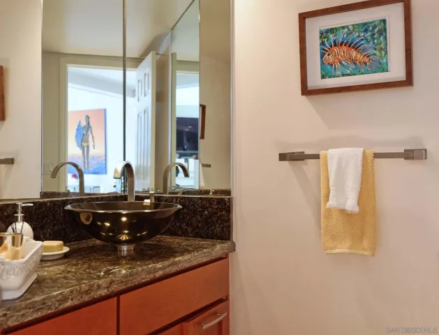 a bathroom with a granite countertop sink and a mirror