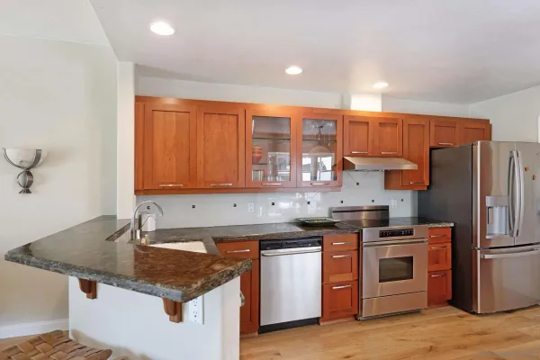 a kitchen with stainless steel appliances granite countertop a sink stove and refrigerator