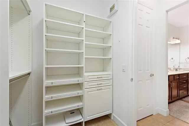 a view of walk in closet with empty racks