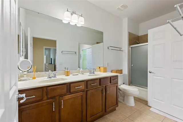 a bathroom with a double vanity sink mirror and toilet