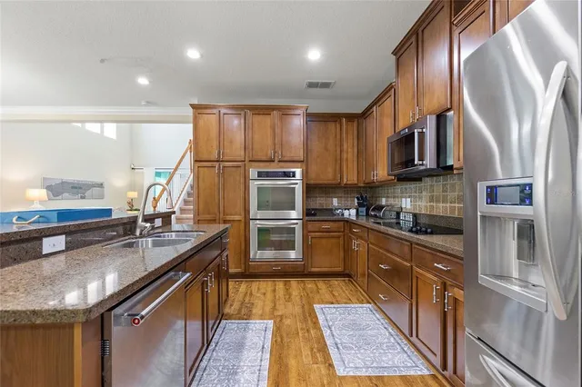 a kitchen with kitchen island granite countertop a sink appliances cabinets and counter space