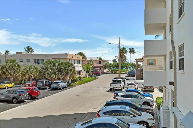 a city street with cars parked in front of it