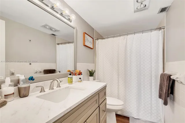 a bathroom with a sink a toilet and mirror