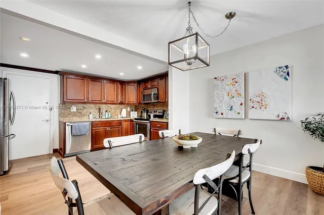 a dining room with wooden floor and a chandelier