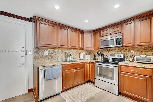 a kitchen with granite countertop appliances cabinets and a sink
