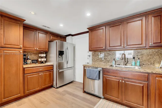 a kitchen with stainless steel appliances granite countertop a refrigerator sink and cabinets