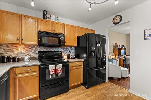 a kitchen with stainless steel appliances granite countertop a refrigerator a stove top oven a sink and dishwasher
