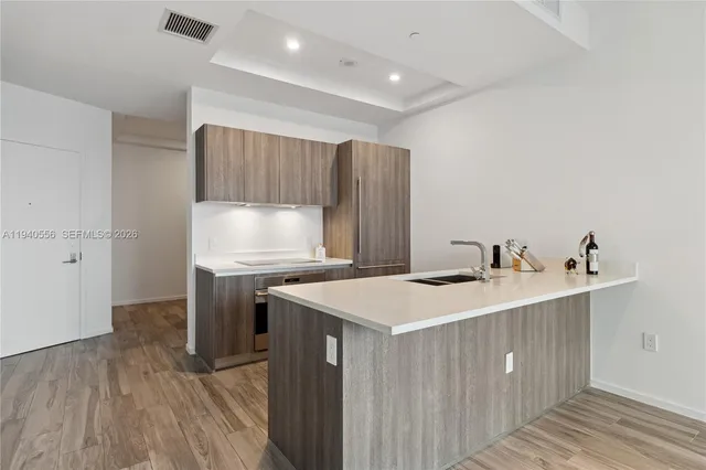 a kitchen with a sink cabinets and wooden floor