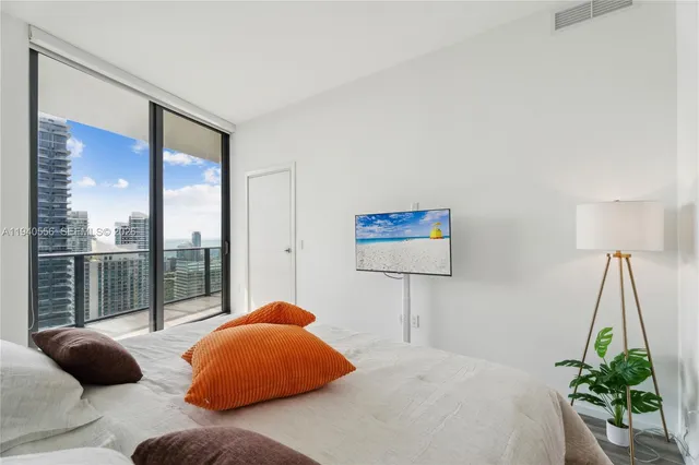 a bedroom with a bed and a large window