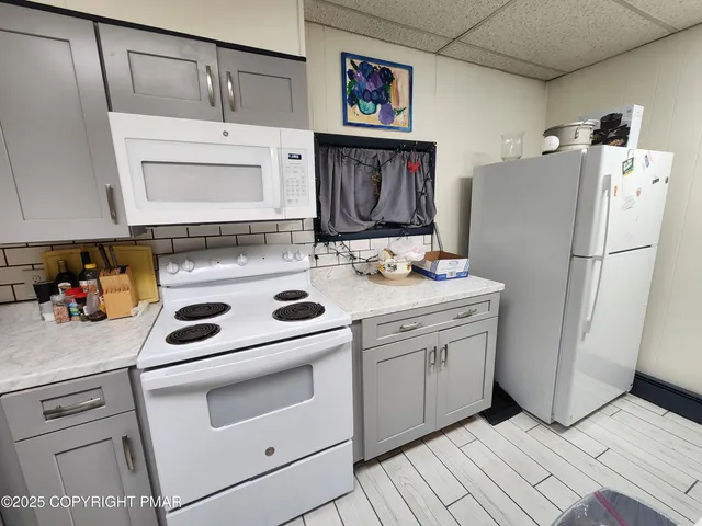 a kitchen with refrigerator cabinets and wooden floor