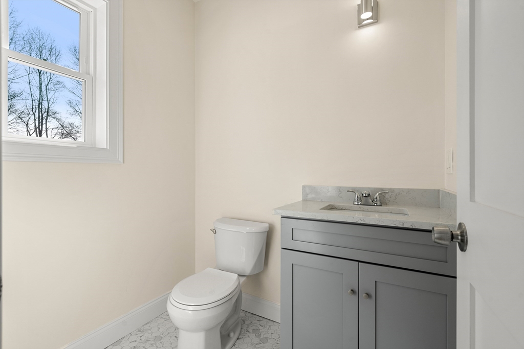 13 River Street, Unit 1 Danvers, MA 01923 - Photo 13 of 23 a bathroom with a granite countertop toilet and a sink
