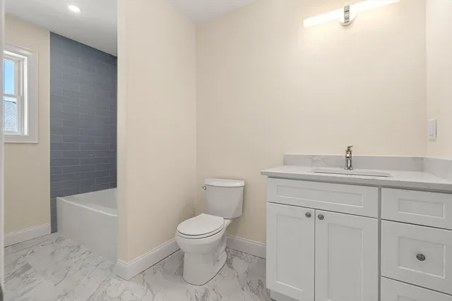 a bathroom with a toilet a sink and bathtub