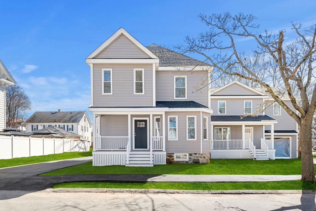 13 River Street, Unit 1 Danvers, MA 01923 - Photo 2 of 23 a front view of a house with a yard and garage