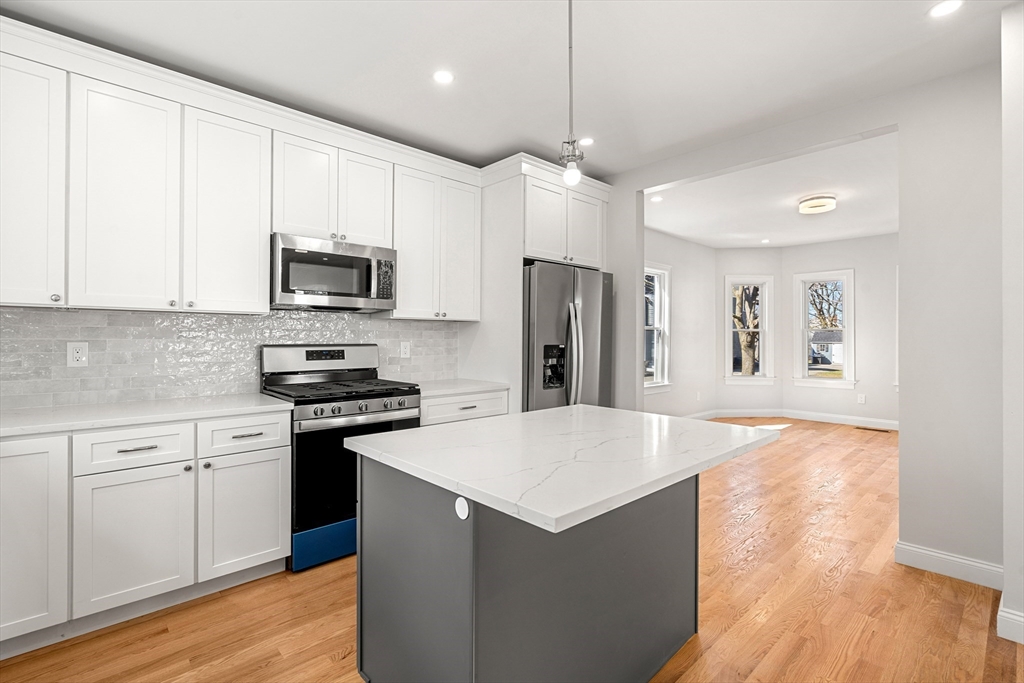 13 River Street, Unit 1 Danvers, MA 01923 - Photo 7 of 23 a kitchen with stainless steel appliances a refrigerator a stove a sink and white cabinets