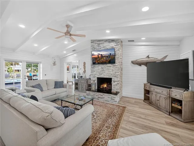 a living room with furniture a flat screen tv and a fireplace