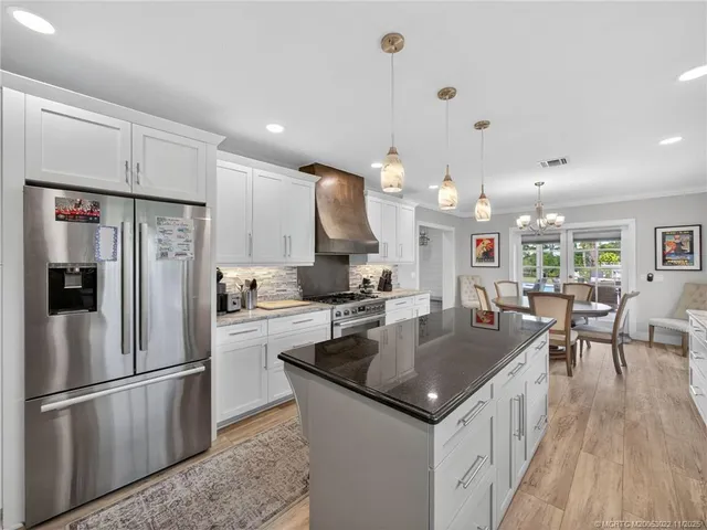 a kitchen with a center island wooden floor and stainless steel appliances