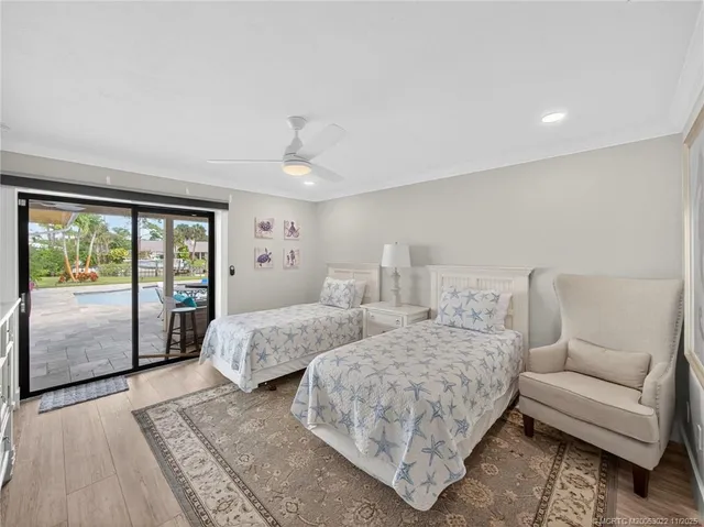 a bedroom with two beds and large window