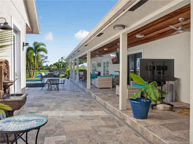 a view of a patio with table and chairs potted plants