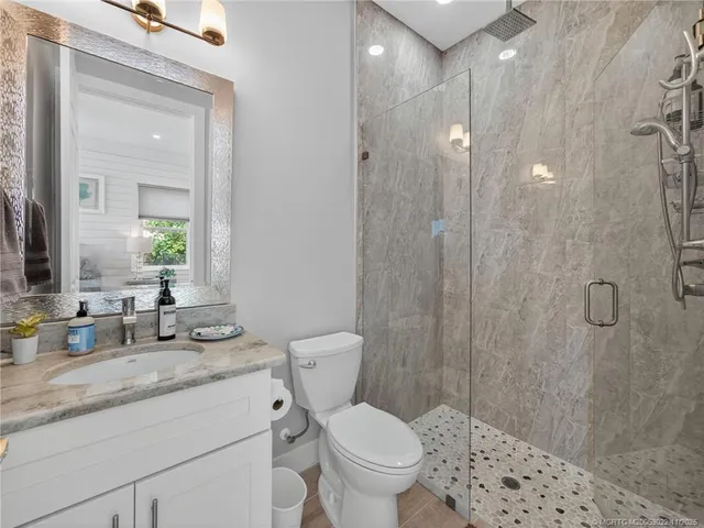 a bathroom with a granite countertop sink toilet and shower