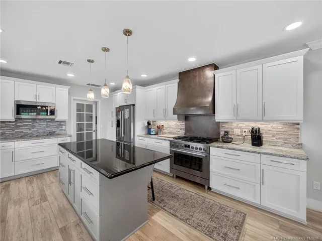 a kitchen with stainless steel appliances granite countertop a sink stove and refrigerator