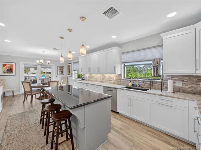 a kitchen with center island white cabinets and stainless steel appliances