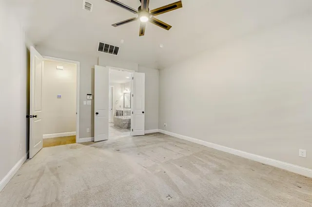 an empty room with closet and a chandelier fan