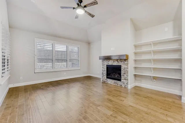 a view of an empty room with a fireplace and a window