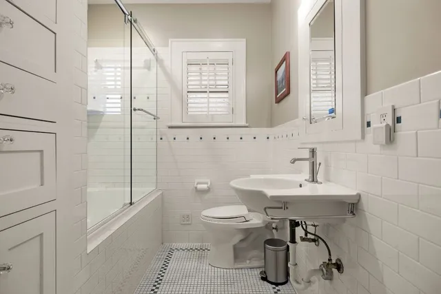 a bathroom with a sink a toilet and a mirror