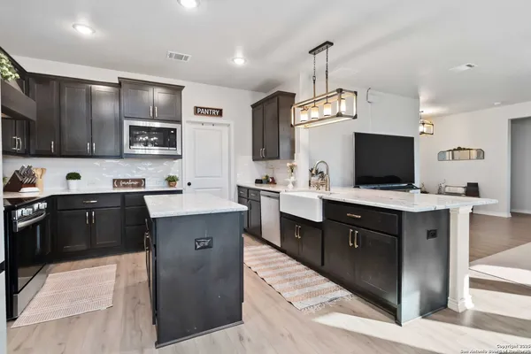 a kitchen with kitchen island granite countertop stainless steel appliances stove a sink and a microwave