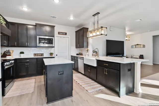 a kitchen with kitchen island granite countertop stainless steel appliances stove a sink and a microwave