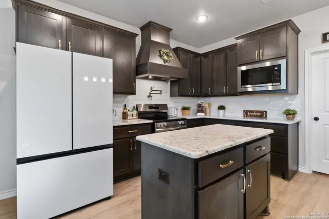 a kitchen with kitchen island a sink stainless steel appliances and cabinets