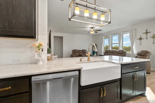 a kitchen with a sink dishwasher a stove and a microwave oven with cabinets