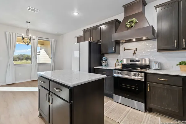a kitchen with stainless steel appliances granite countertop a stove a refrigerator and a sink