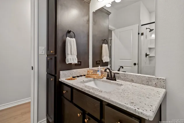 a bathroom with a granite countertop sink and a mirror