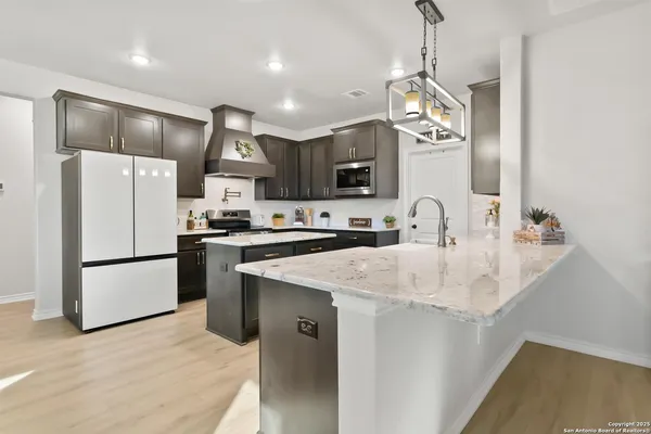 a kitchen with stainless steel appliances granite countertop a sink a refrigerator a stove a microwave and a refrigerator