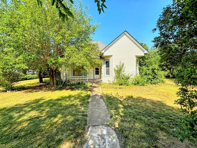 a front view of a house with yard and green space