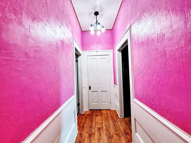 a kitchen with stainless steel appliances a sink dishwasher a stove and white cabinets with wooden floor