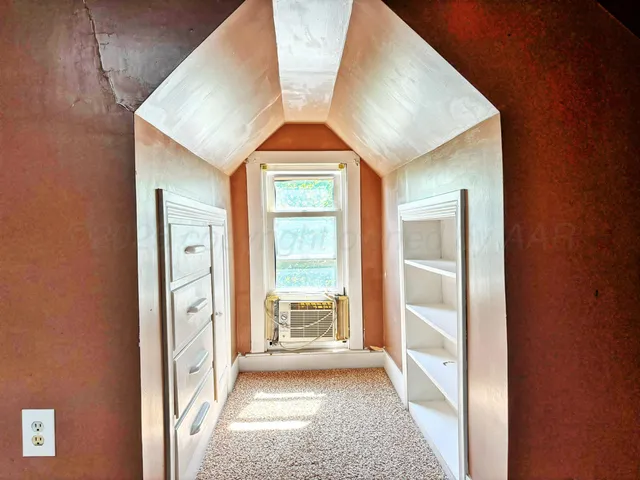 an empty room with closet and a chandelier fan